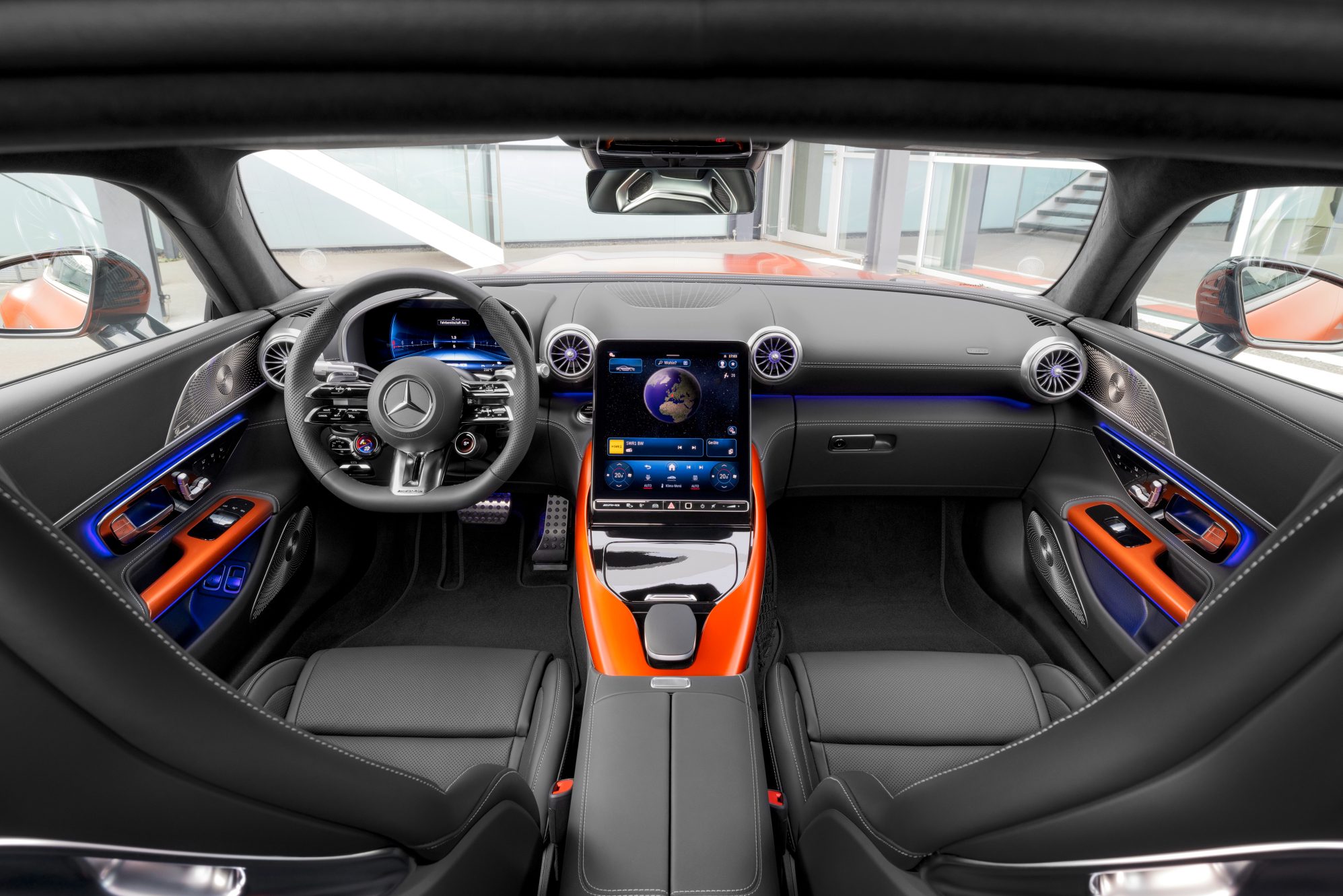 2025 Mercedes-AMG GT 63 S E Performance front seats and dashboard shot from second row parked in front of a glass-walled building.