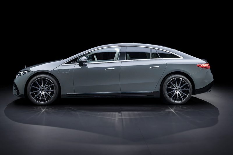 2025 Mercedes-Benz EQS in MANUFAKTUR Signature Silicon Grey direct left profile view on gray reflective flooring and a black background.