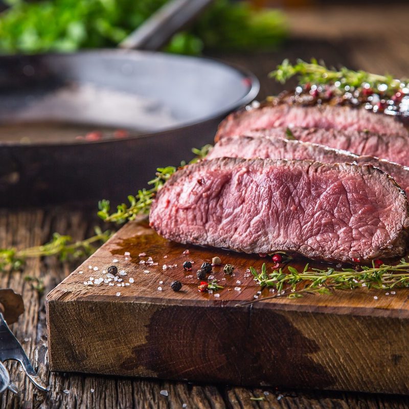 Sliced steak on cutting board