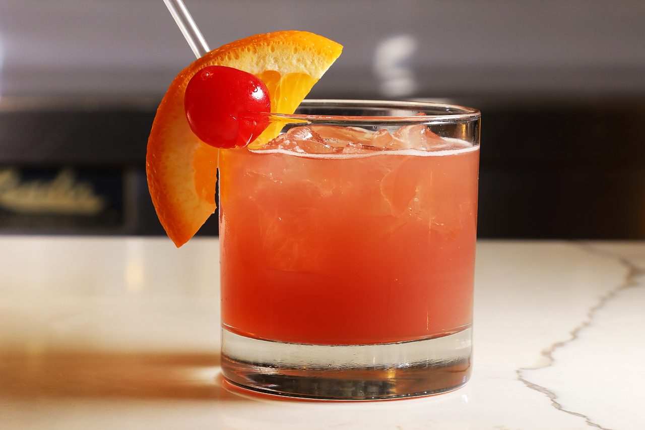 orange pink cocktail with orange slice.