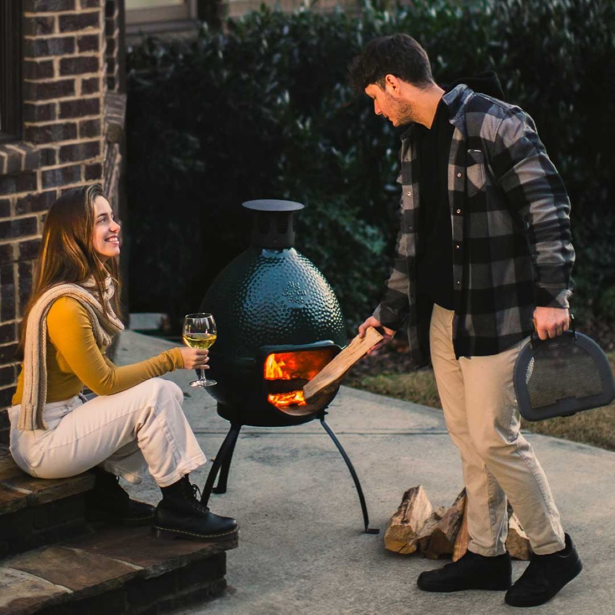 A couple enjoying the warmth of a Chiminea.