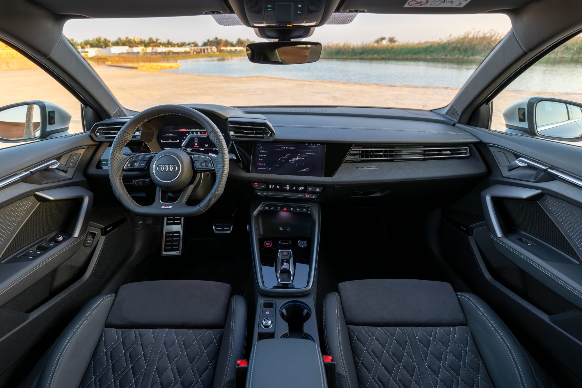 Blue 2025 Audi S3 interior view of the front seating area and dashboard taken directly centered from high in the second row.