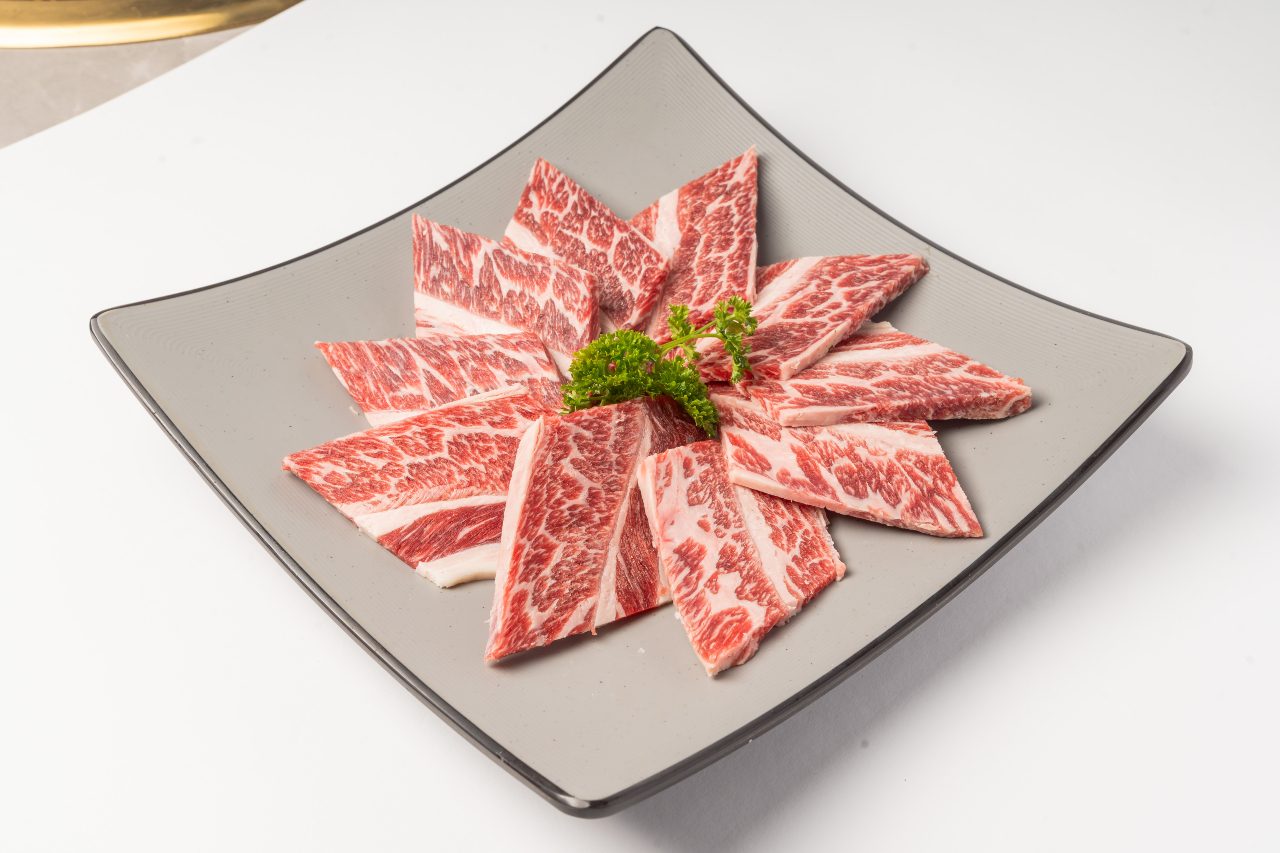 sliced short ribs on square plate.