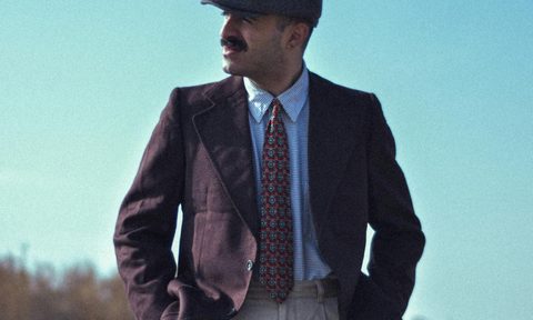 Man in newsboy cap and pleated trousers