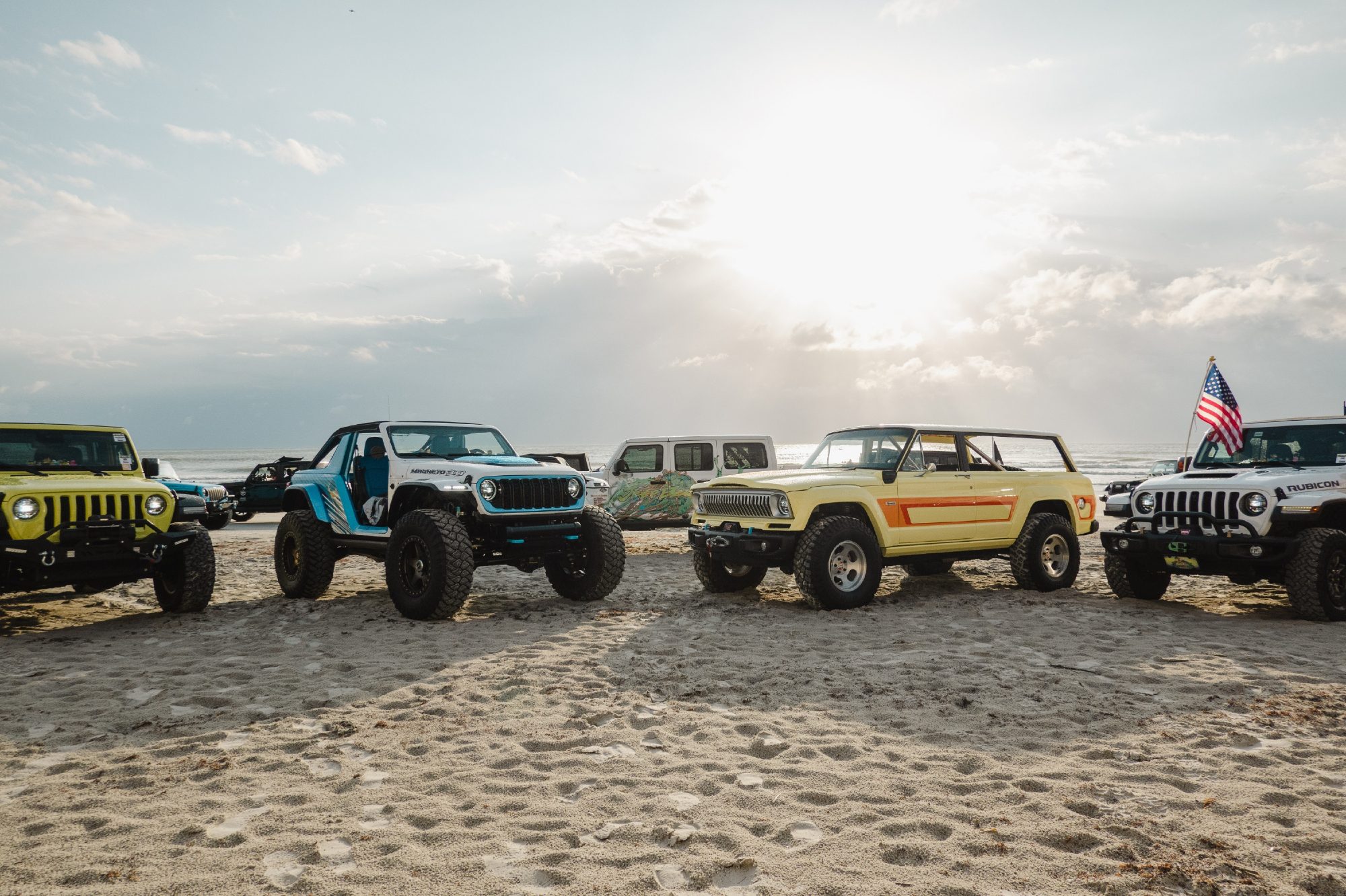 Photo from Jeep Beach Week 2023 with a line up of various Jeep models and vintages.