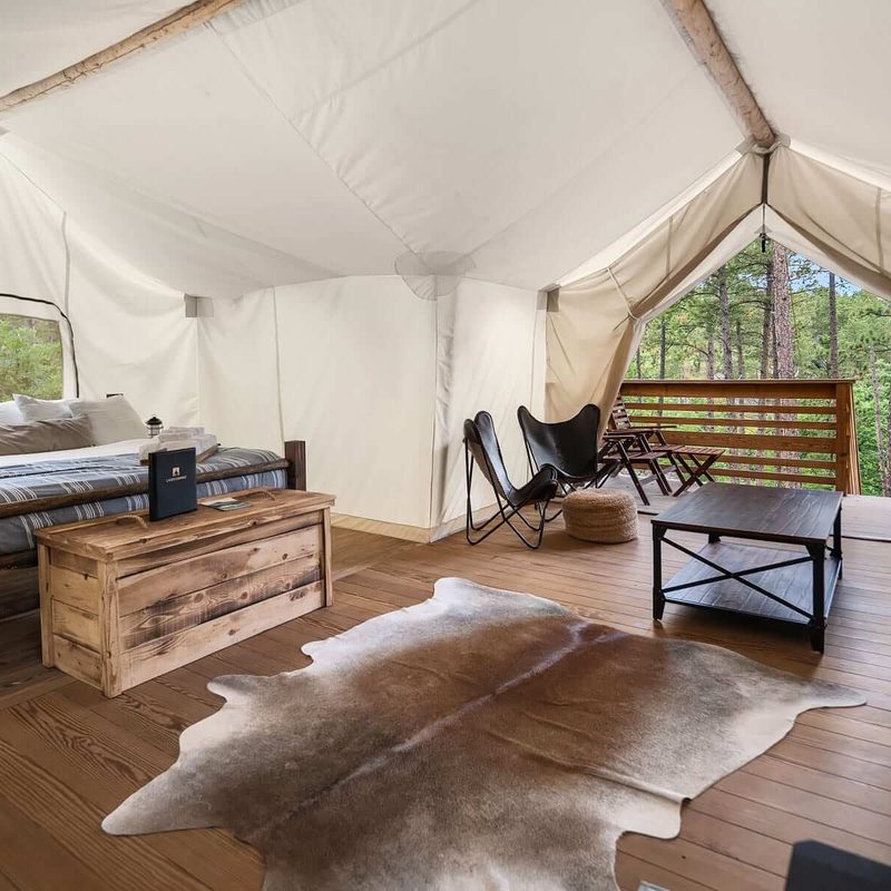 A large white glamping tent with a bed and a porch