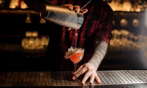 Barman pouring paper plane cocktail