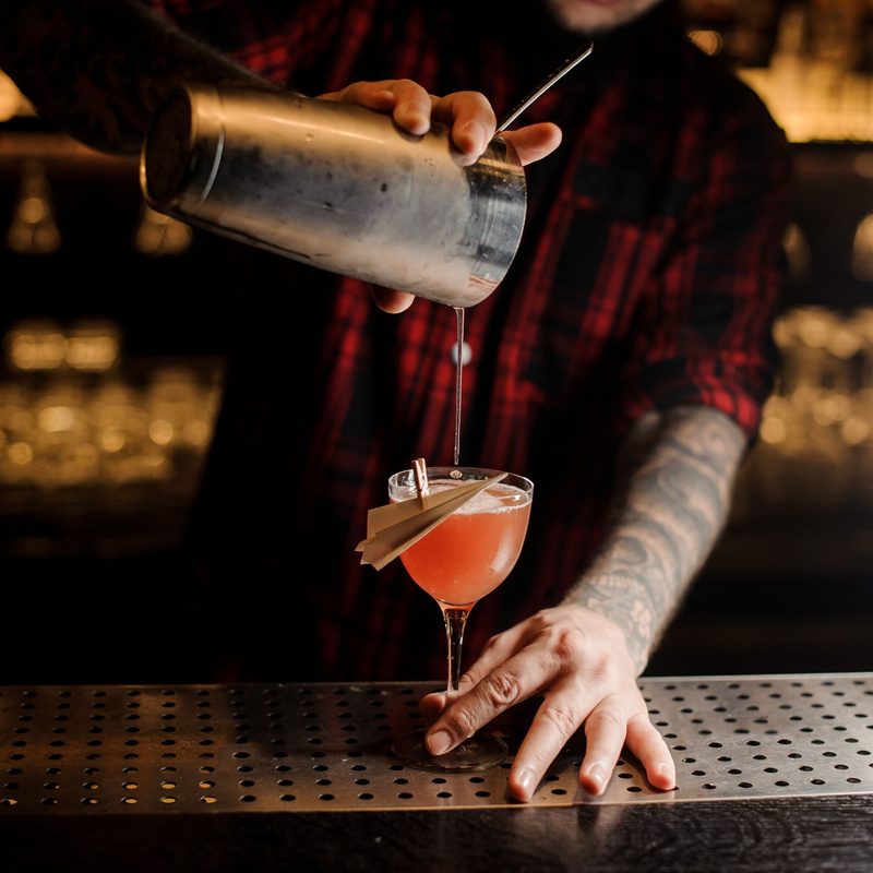 Barman pouring paper plane cocktail