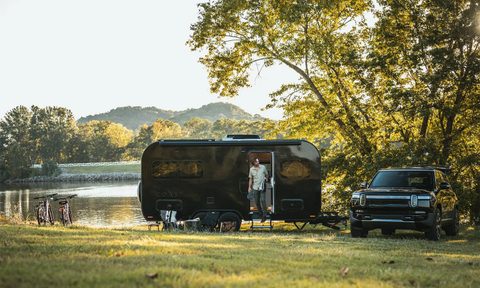 Coast Model 1 solar electric travel trailer/RV parked near a pond.