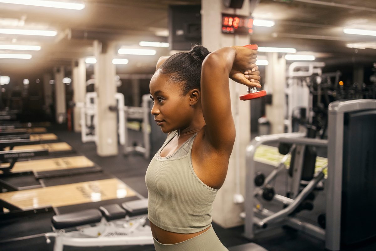 Woman doing dumbbell tricep exercise.
