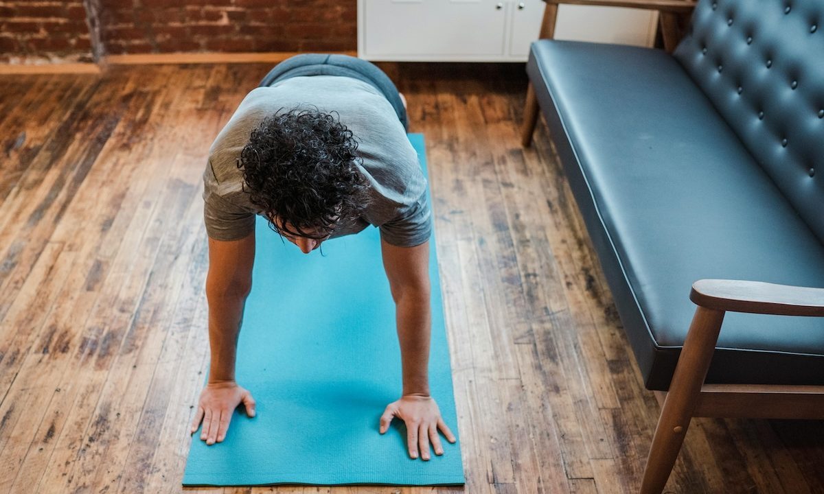 a man doing a plank on a yoga mat