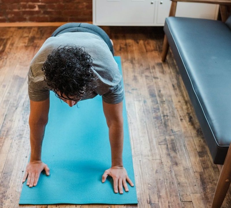 a man doing a plank on a yoga mat