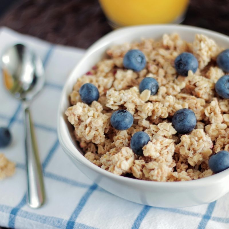 A bowl of oatmeal and blueberries on a placemat