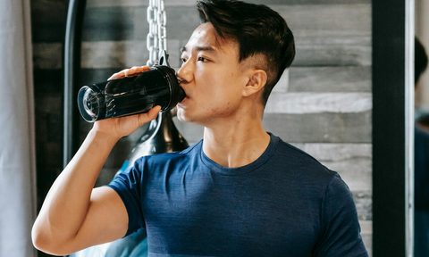 Man drinking from shaker bottle.