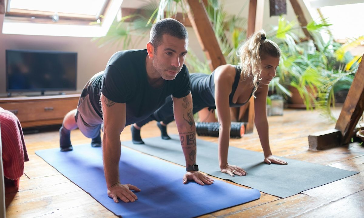 man and woman doing planks studio fitness class