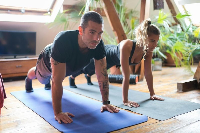 Man and woman doing planks studio fitness class