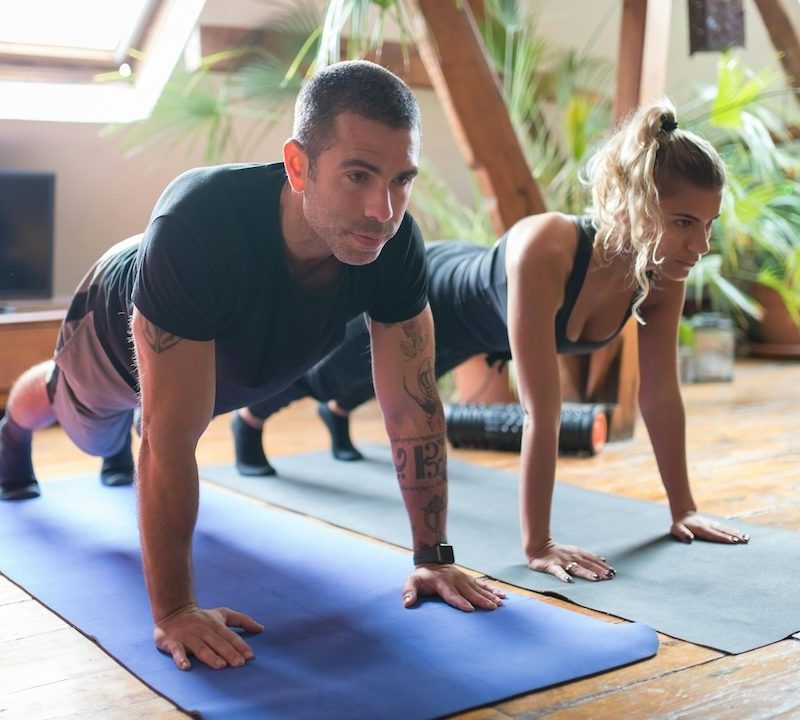 Man and woman doing planks studio fitness class