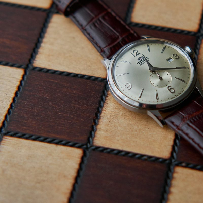 Orient watch on checkered table