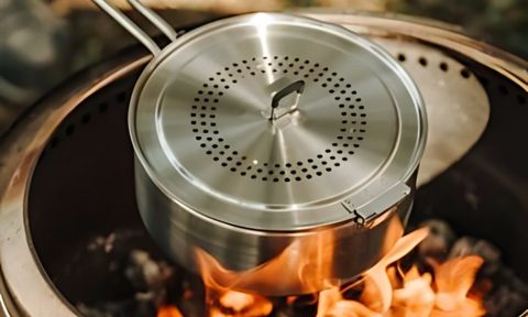 A solo stove popcorn maker placed over a solo stove standalone fire pit