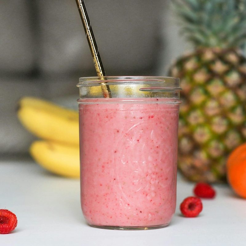 a raseberry smoothie in a mason jar on a table