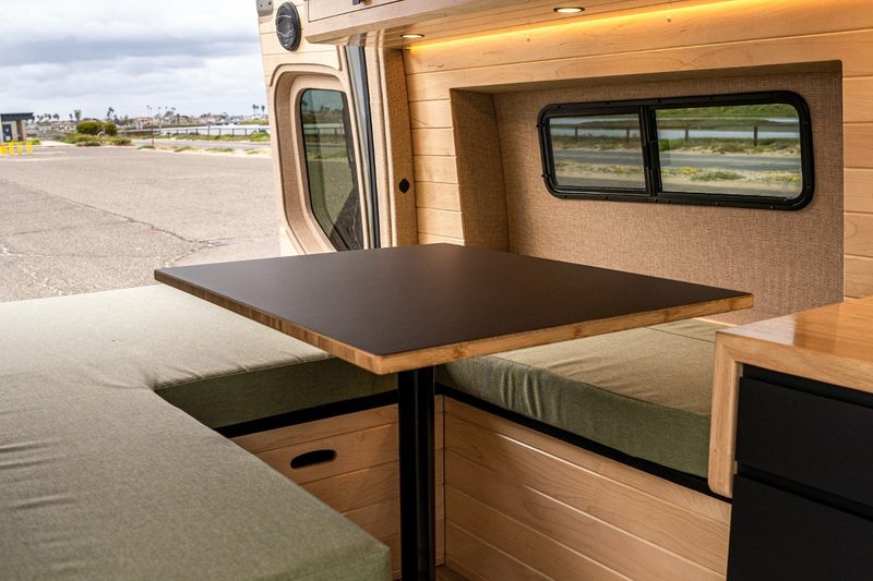 Convertible bed/dinette setup inside Vanspeed's California Coast camper van.