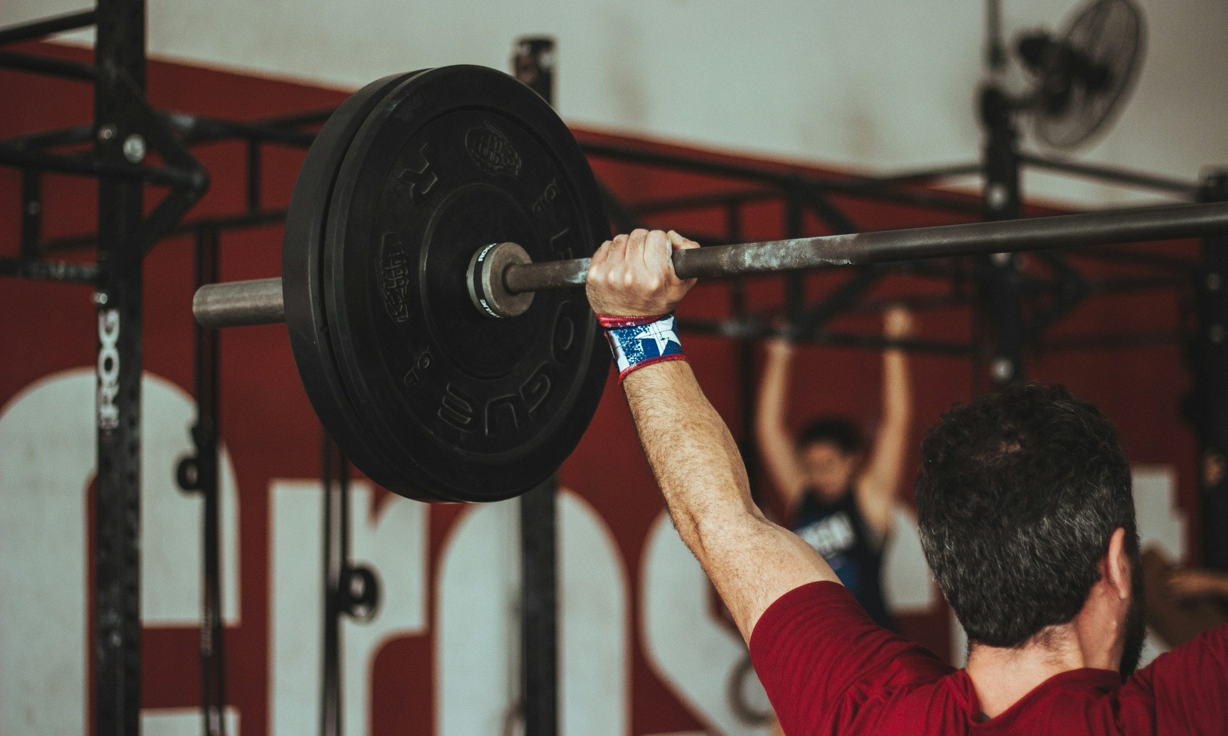 push press exercise man lifting weight over head in gym