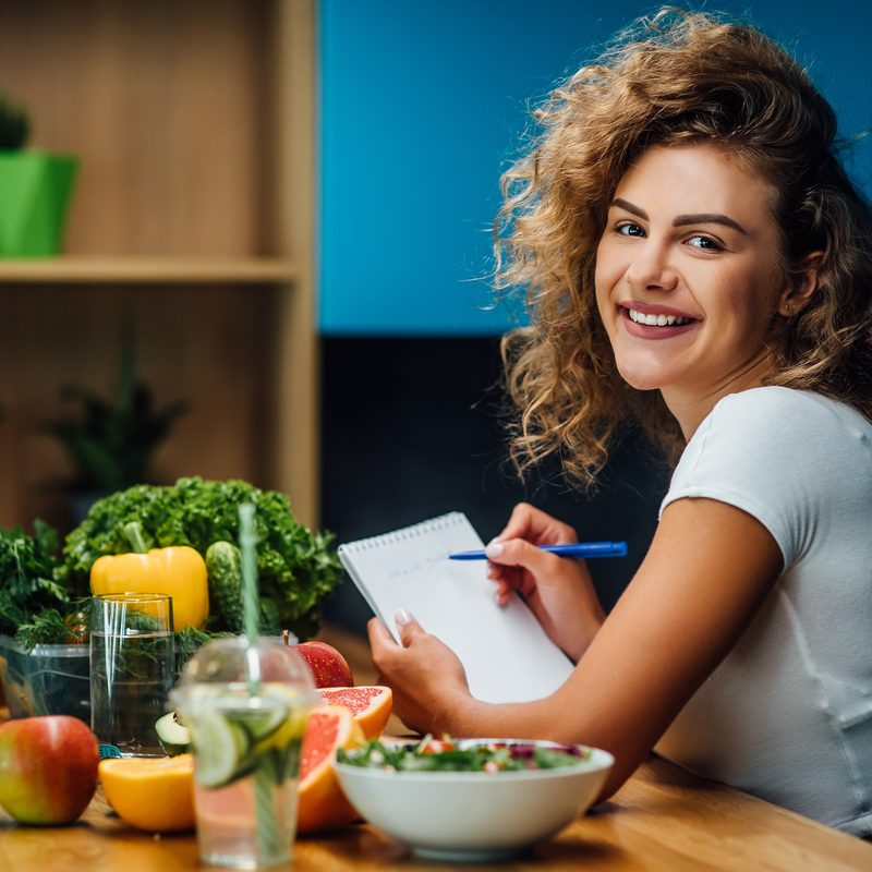 Woman holding notepad in kitchen