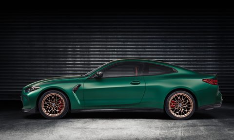 2025 BMW M4 CS driver side profile shot parked in a garage with a corrugated wall.