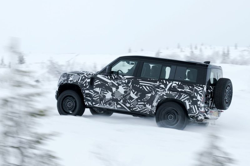 2025 Defender OCTA limited high-performance edition climbing out of snow onto a windswept road.