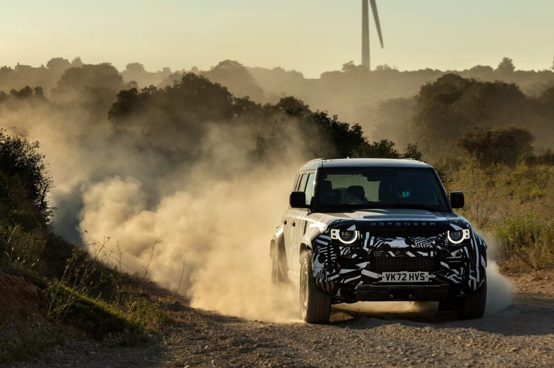 2025 Defender OCTA limited high-performance edition driving fast on a dirt road with dust blowing