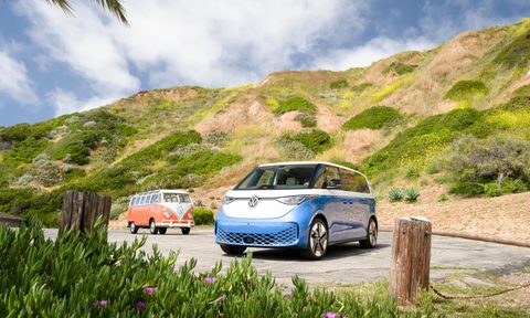 2025 VW ID. Buzz and vintage VW Bus parked in front of rolling hills.
