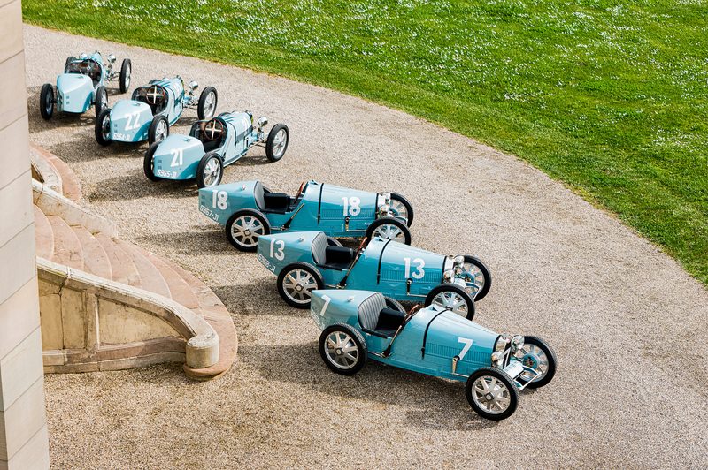 All six Bugatti Baby II Type 35 Centenary Editions on the gravel drive entry of Château Saint Jean in Molsheim.