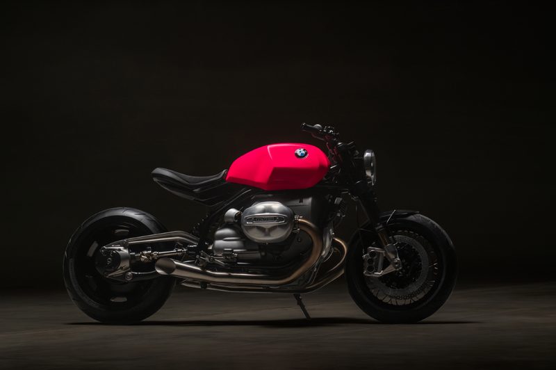 BMW Motorrad BMW R20 Concept motorcycle right profile view parked on a dark brown surface against a black background.