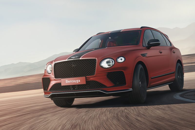 Bentayga Apex Edition limited edition of just 20 cars rounding a curve on a dirt road with fields and mountains in the background.