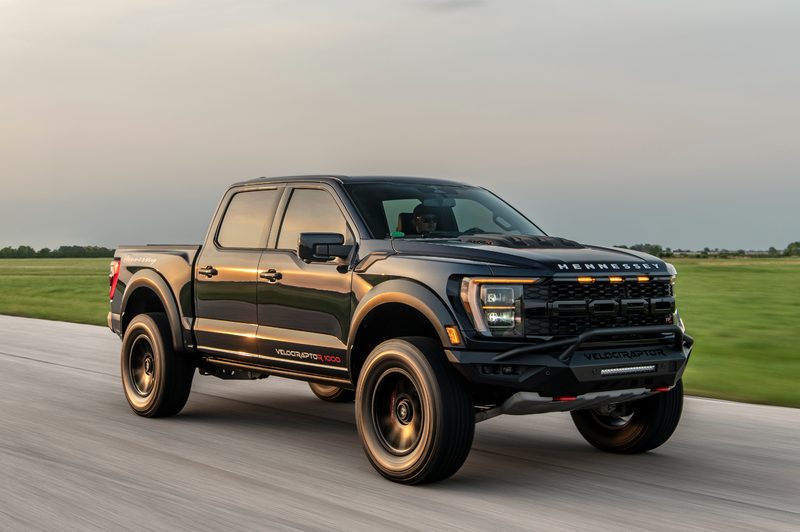 Hennessey Ford VelociRaptoR 1000 Super Truck right front three-quarter view parked on pavement with grass and sky in the background.