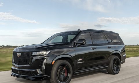 Hennessey H850 Cadillac-V conversion left front three-quarter image driving on a road with grassy field in the background.