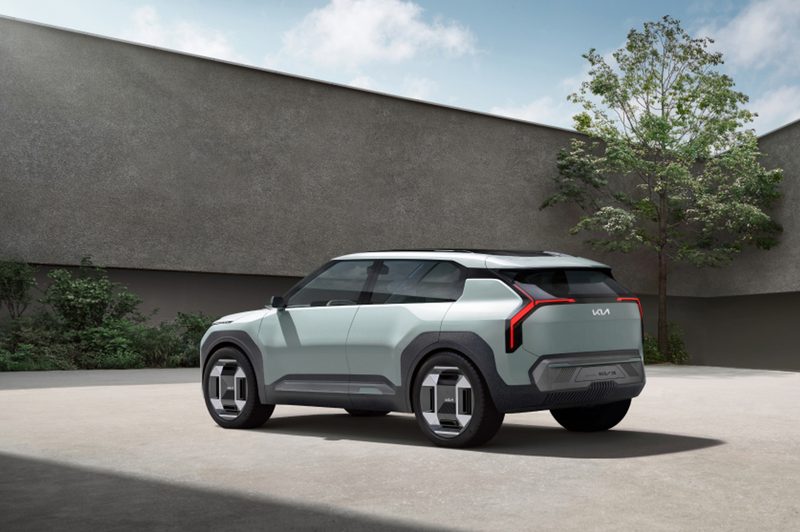 Kia EV3 Concept left rear three-warter view parked near a contemporary house.