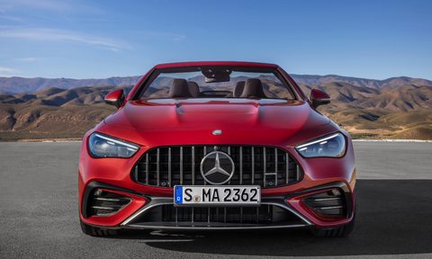 Mercedes-AMG CLE 53 Cabriolet front view red with top down parked on asphalt with hills in background.