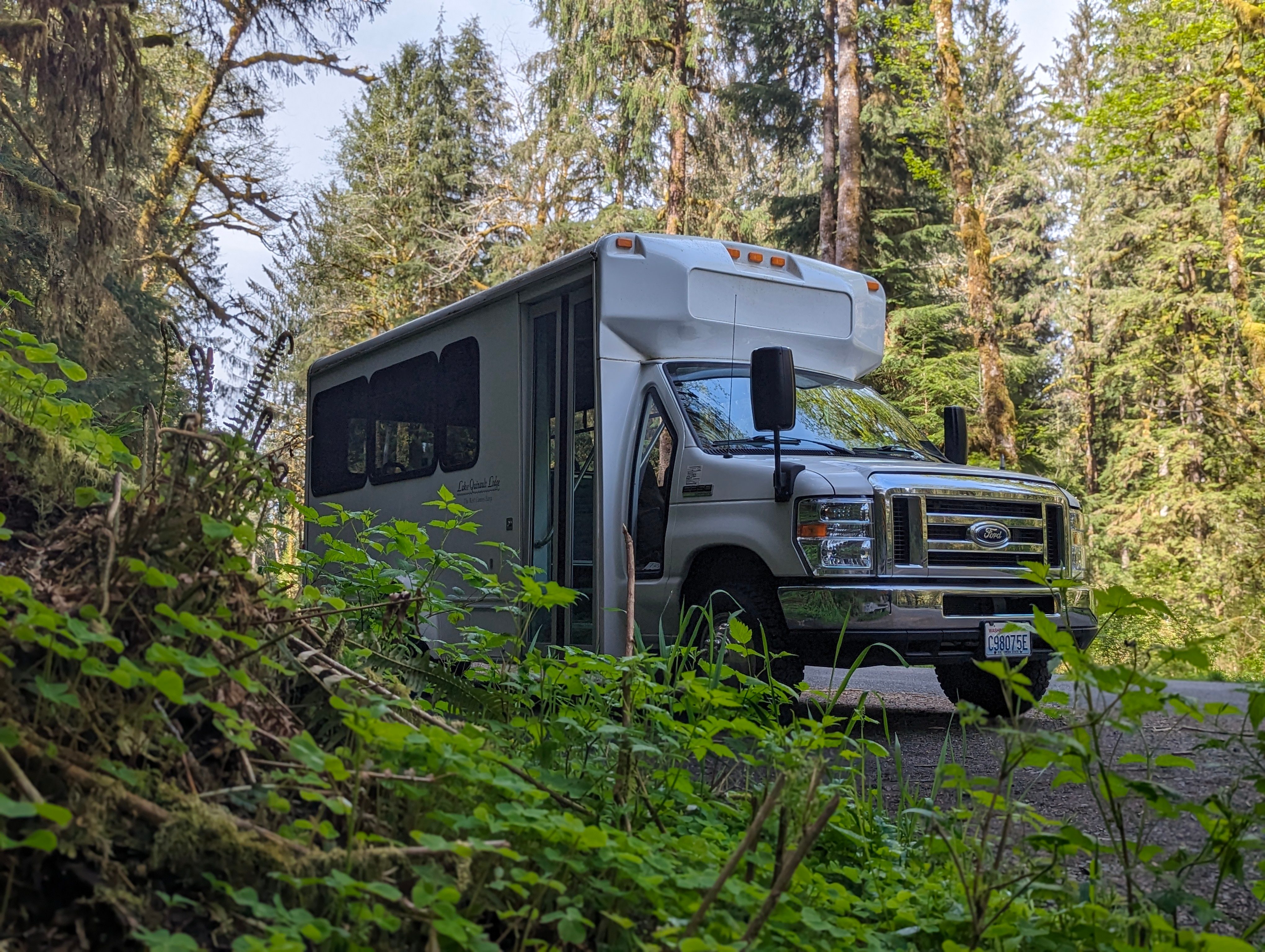 The Quinault Lake Tour van parked outside a waterfall