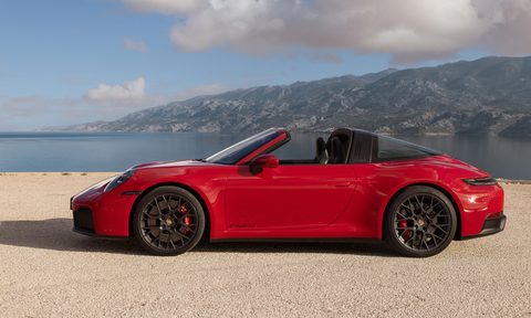 Porsche 911 Targa hybrid left profile parked on sand with a lake and mountain in the background.
