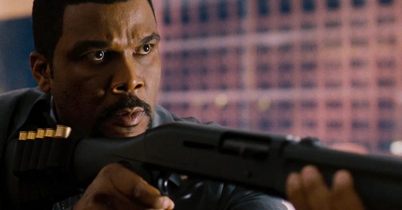 Tyler Perry holding a gun as Alex Cross. 