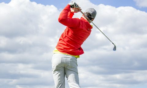 Man swinging golf club.