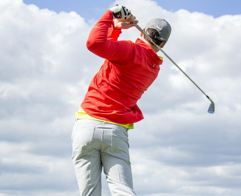 Man swinging golf club.