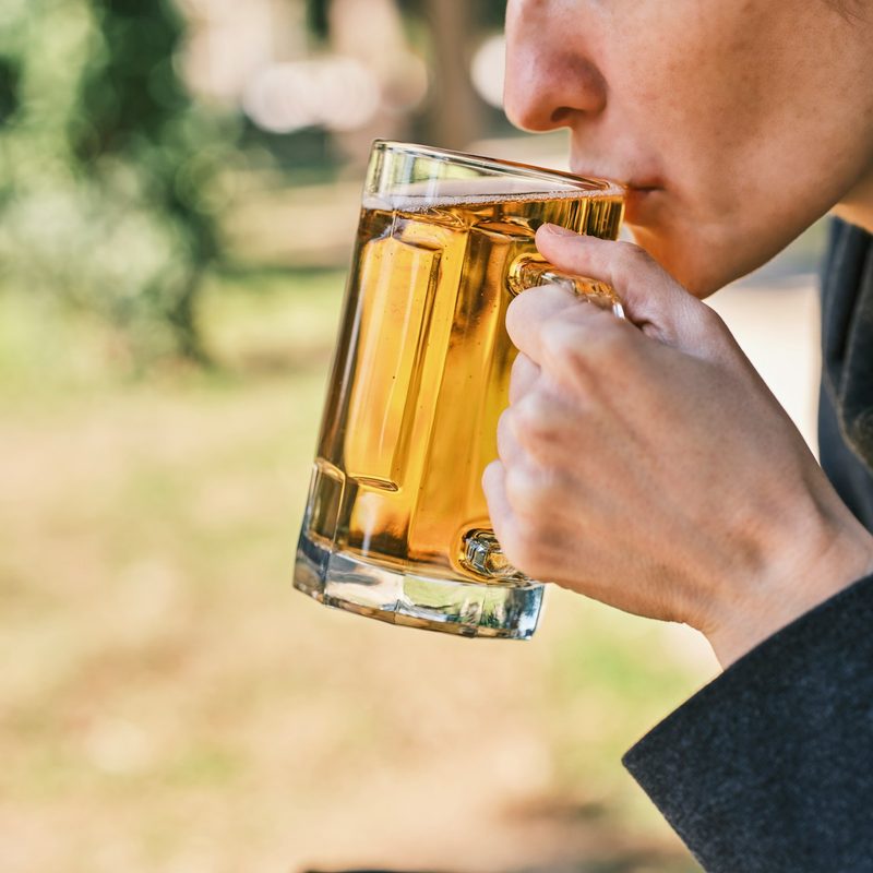 Someone drinking a beer outside