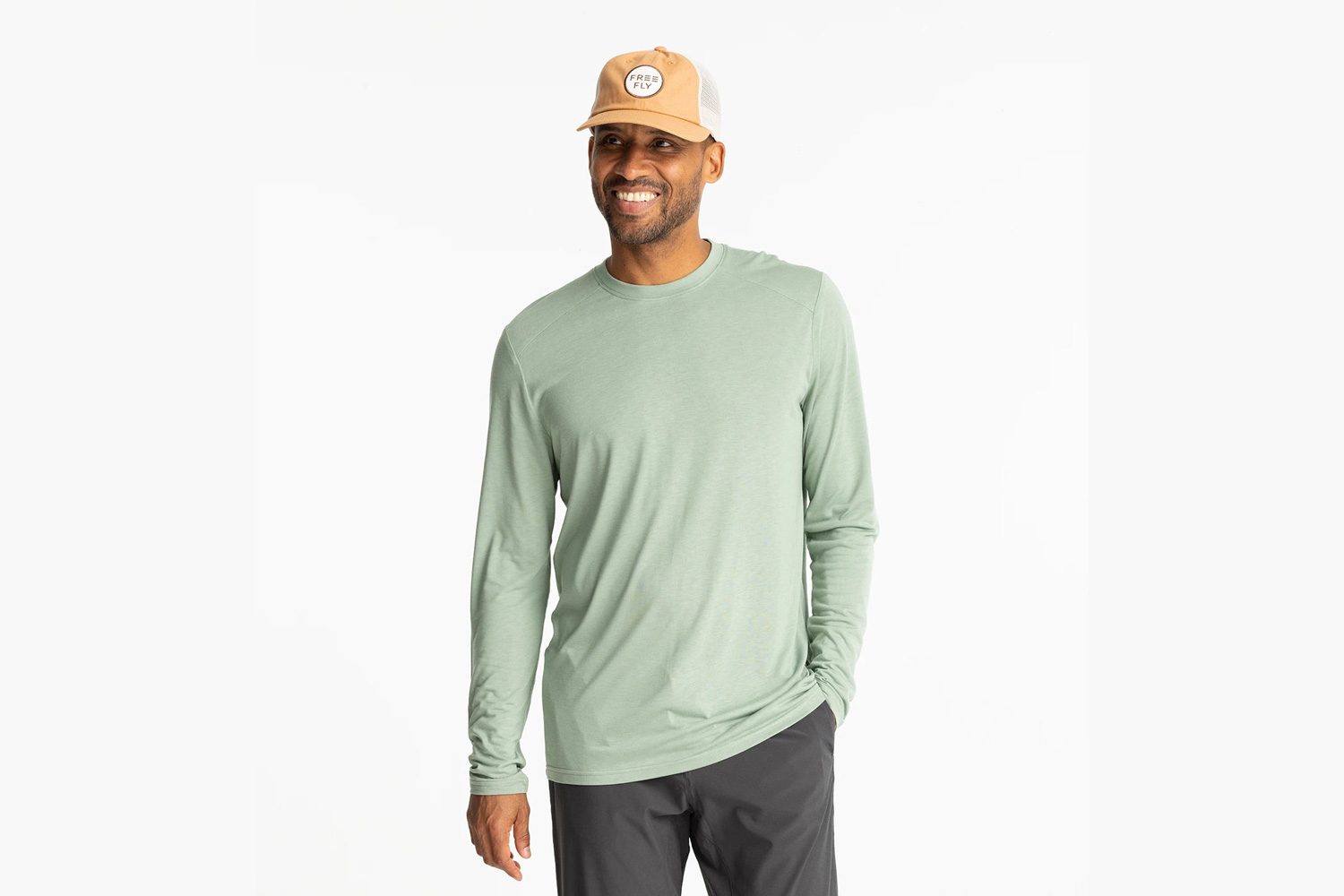 Model wearing Free Fly's Men's Bamboo Lightweight Long Sleeve sun-protection shirt in Palm Green.