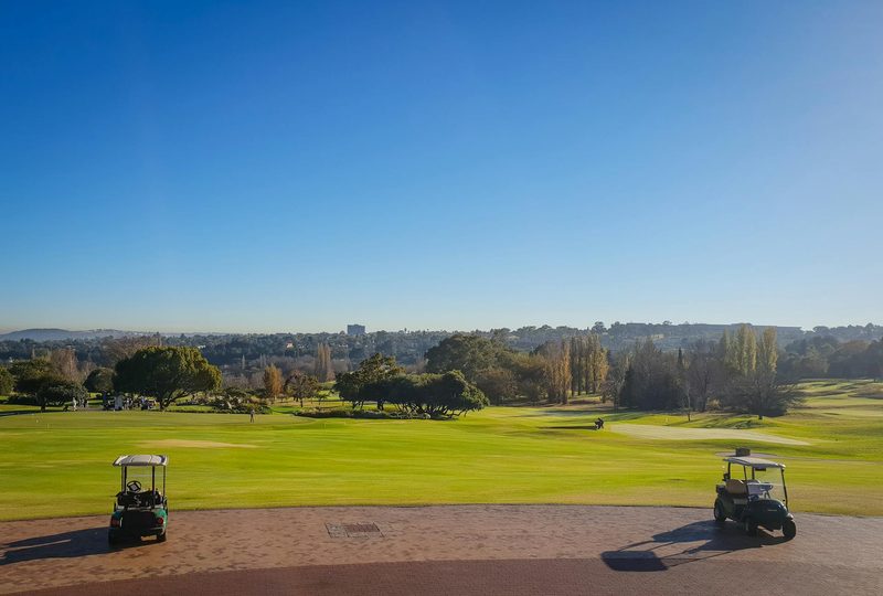 Two golf carts sitting on a golf course.