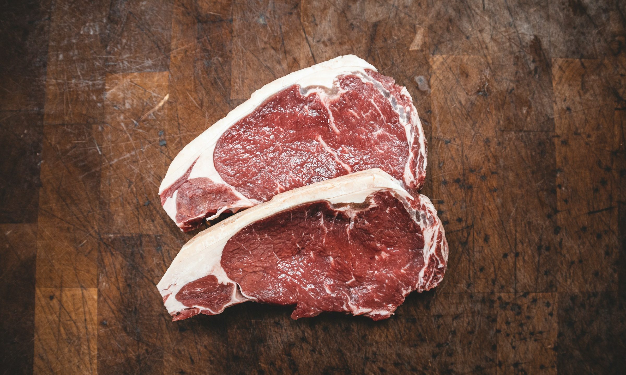 Raw steaks on cutting board