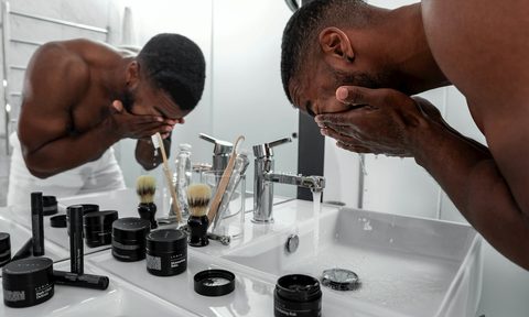 A man washing his face by skincare products