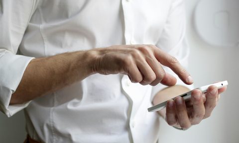 man holding smartphone in white shirt