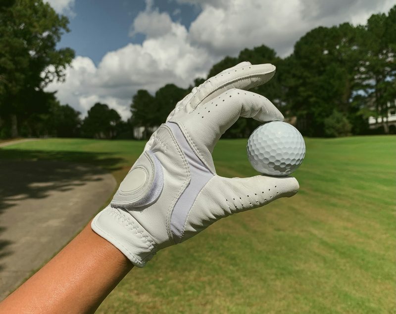 man wearing golf glove holding a golf ball